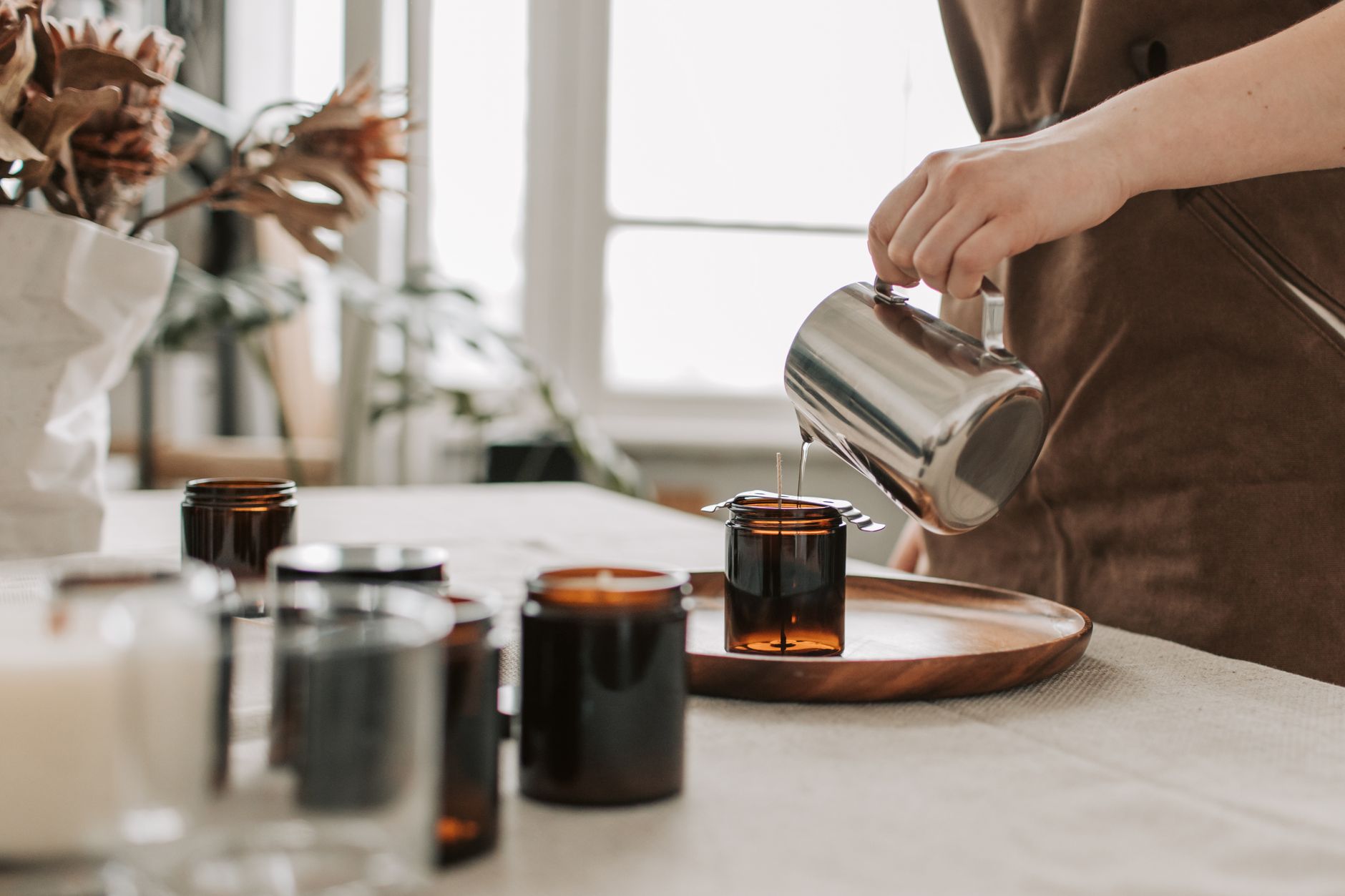 hands pouring soy wax candle